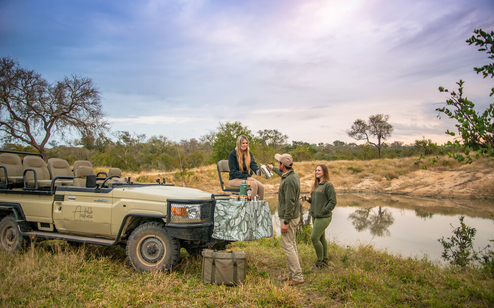 people-standing-next-to-a-safari-vehicle-drinking-coffee